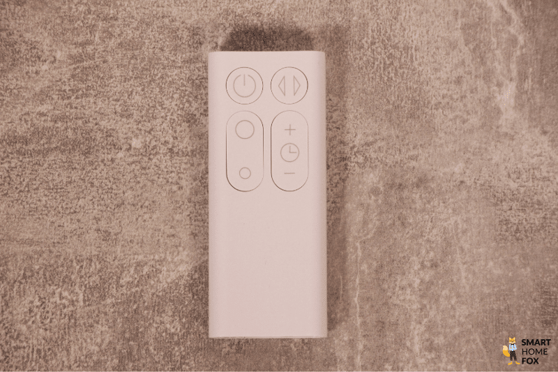 Die weiße Fernbedienung vom Dyson Cool AM07 Turmventilator liegt auf einem grauen Tisch